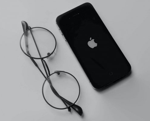 Steve Jobs eye glasses next to an iPhone