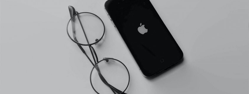 Steve Jobs eye glasses next to an iPhone